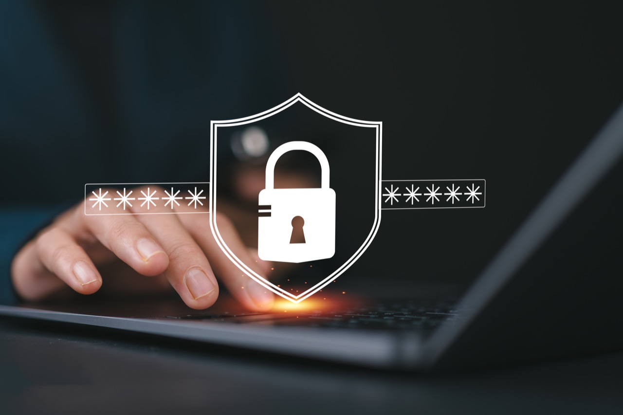 Hände an einem Laptop mit Schloss-Symbol für IT-Sicherheit